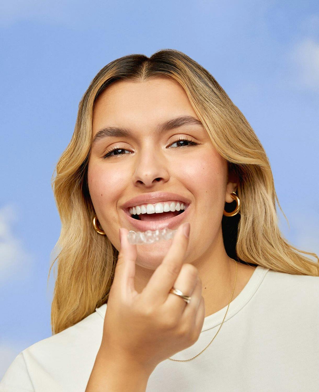 woman smiling holding an aligner