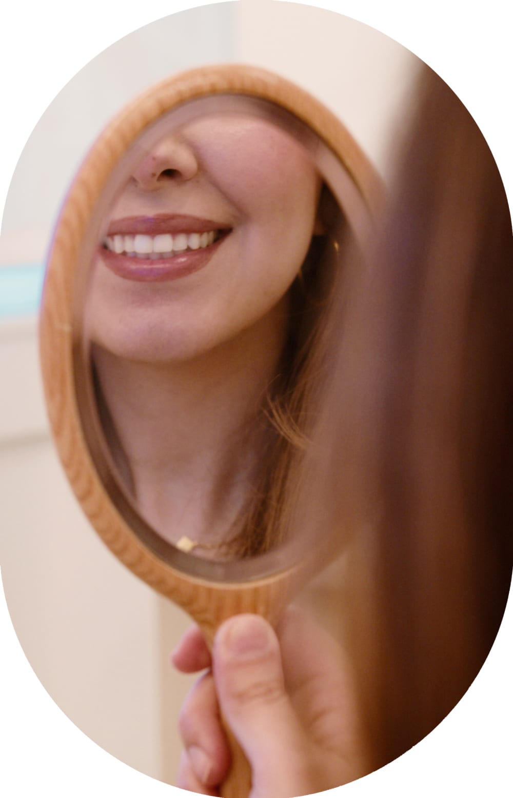 A patient at Tend Dental is looking at their smile in the mirror.
