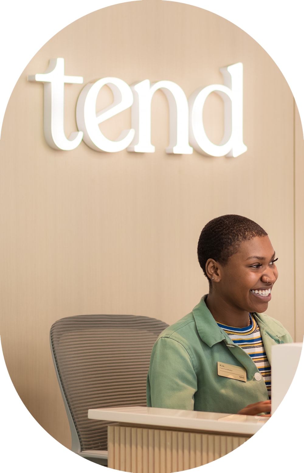 A glowing Tend Dental sign shines above an employee who is on the phone.