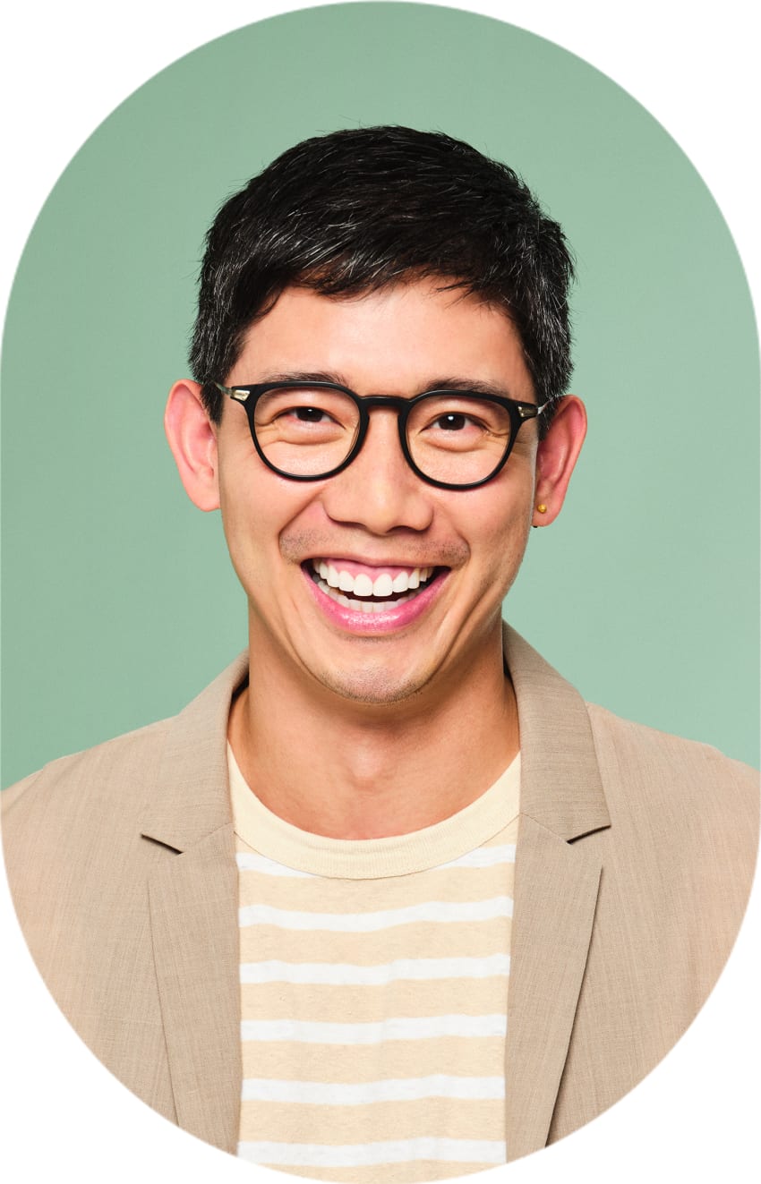 A man with round glasses is smiling.
