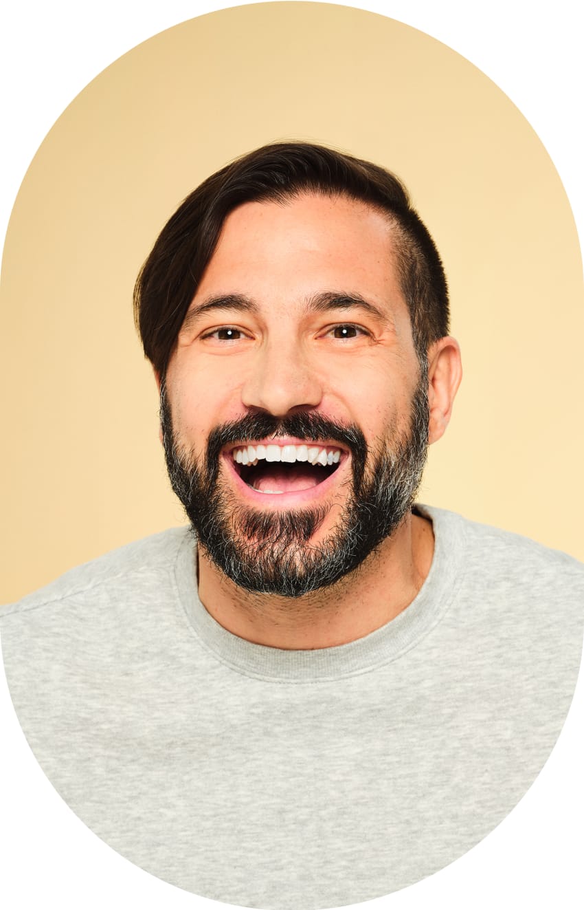 A man is smiling widely with his mouth open.