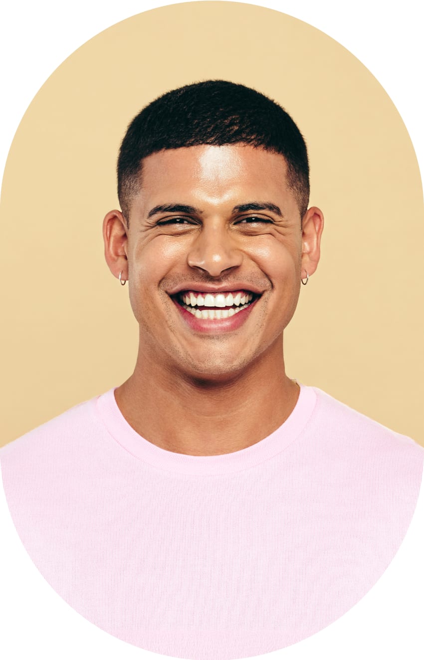 A man is smiling widely, showing off his teeth.