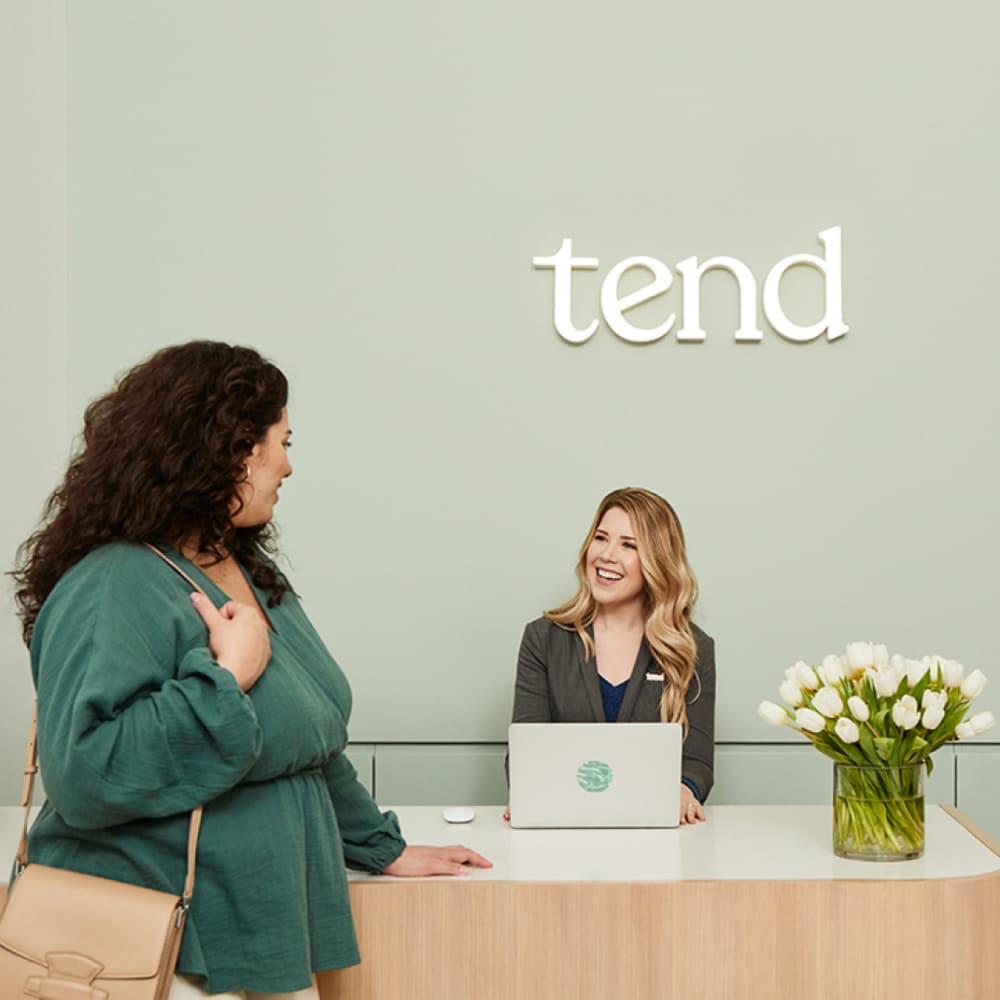 A patient is being greeted by reception at Tend Dental.