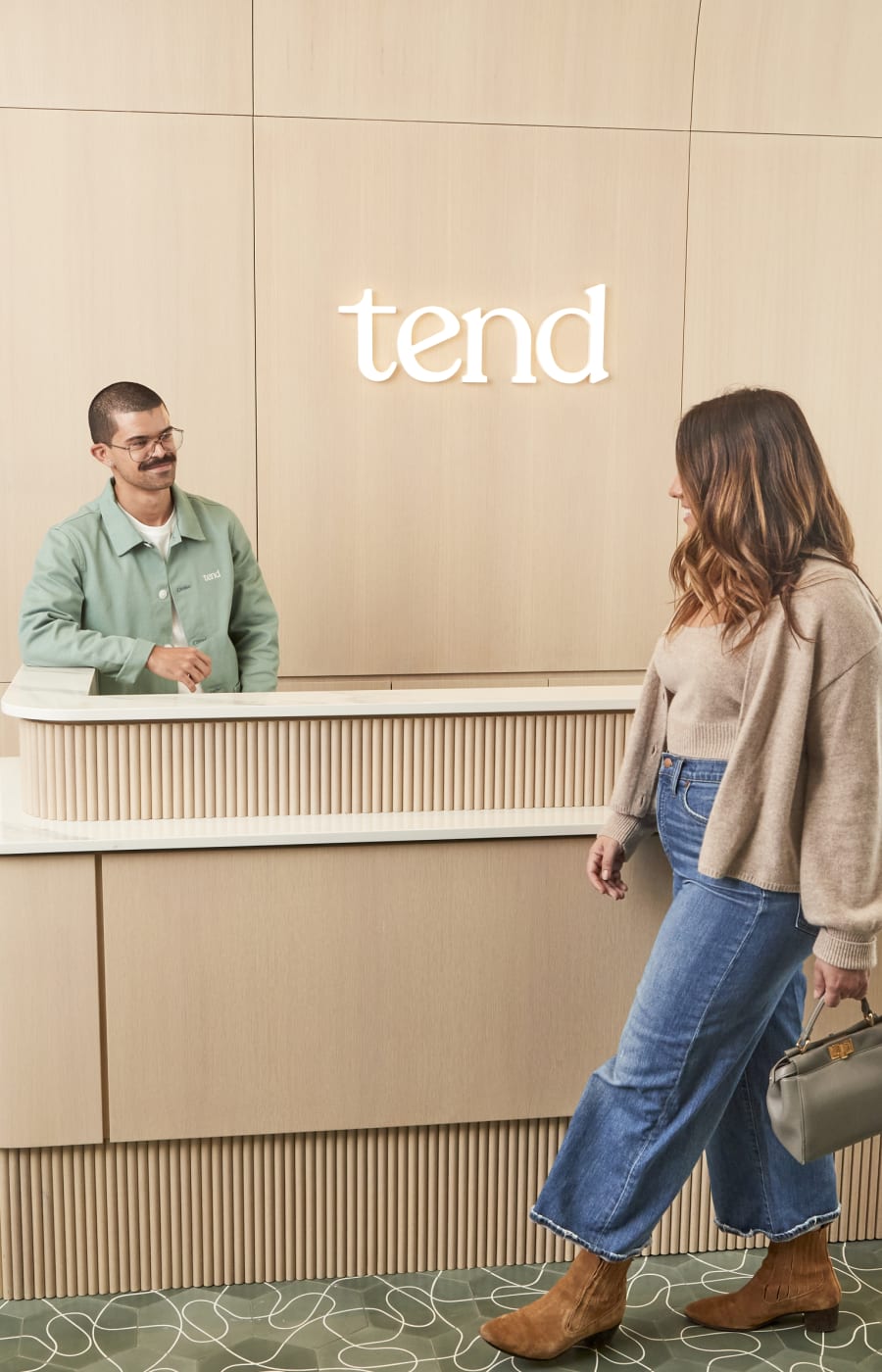 A woman approaches the reception desk at Tend Dental.