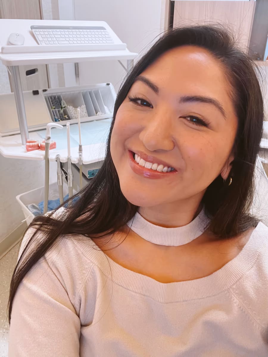 Writer of this article smiling and showing off beautiful straight and even teeth.