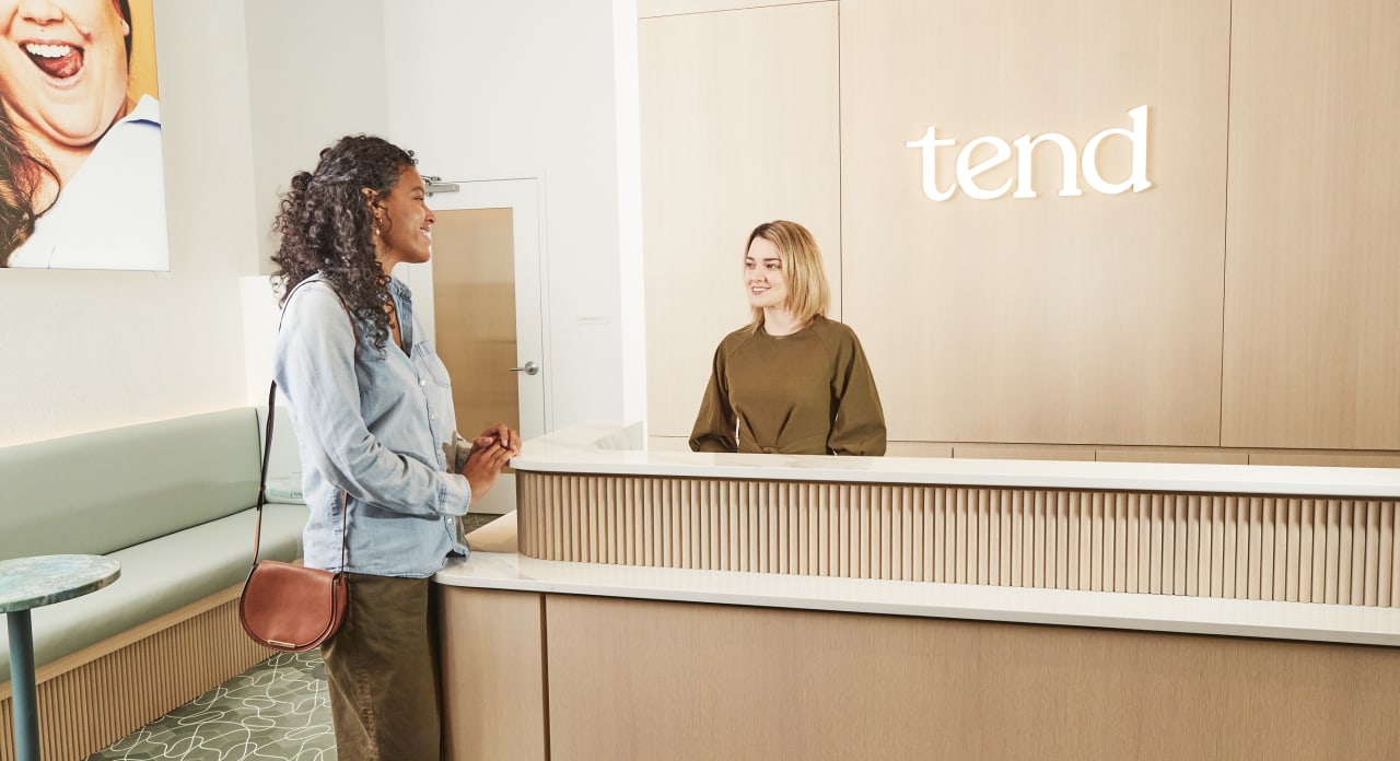 A Tend Dental employee is greeting someone in the lobby.