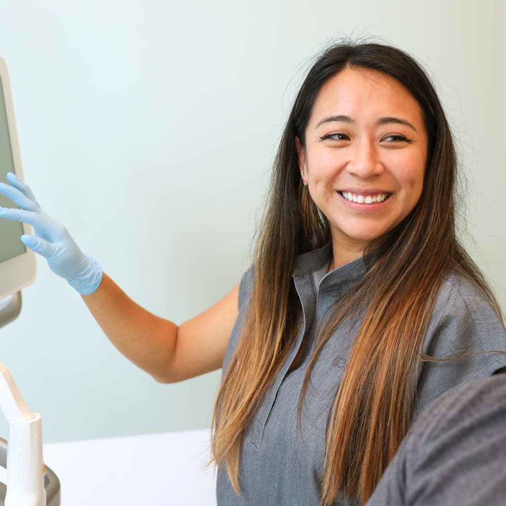 A Tend dental assistant is smiling and looking right.