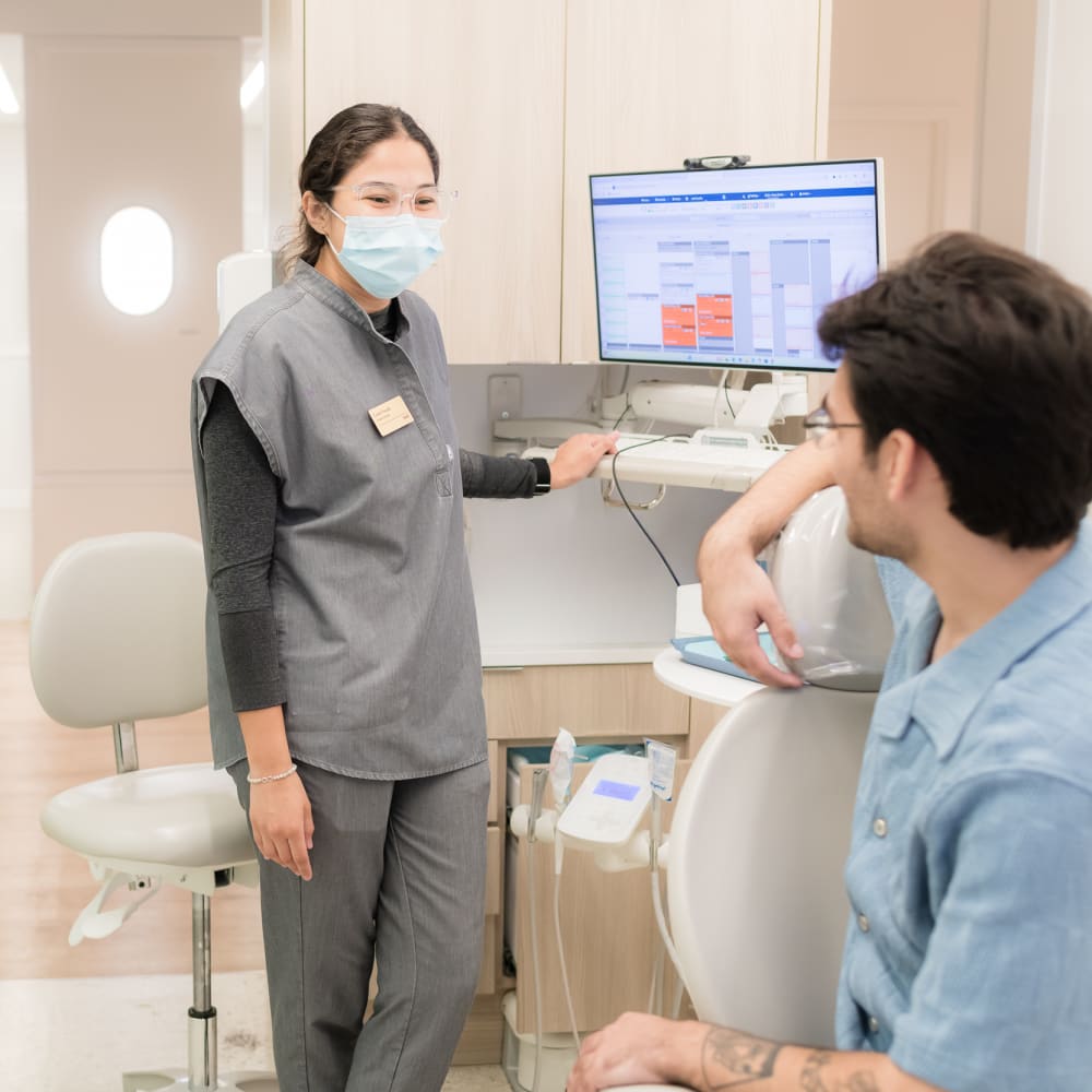Tend dental hygienist and patient are smiling.