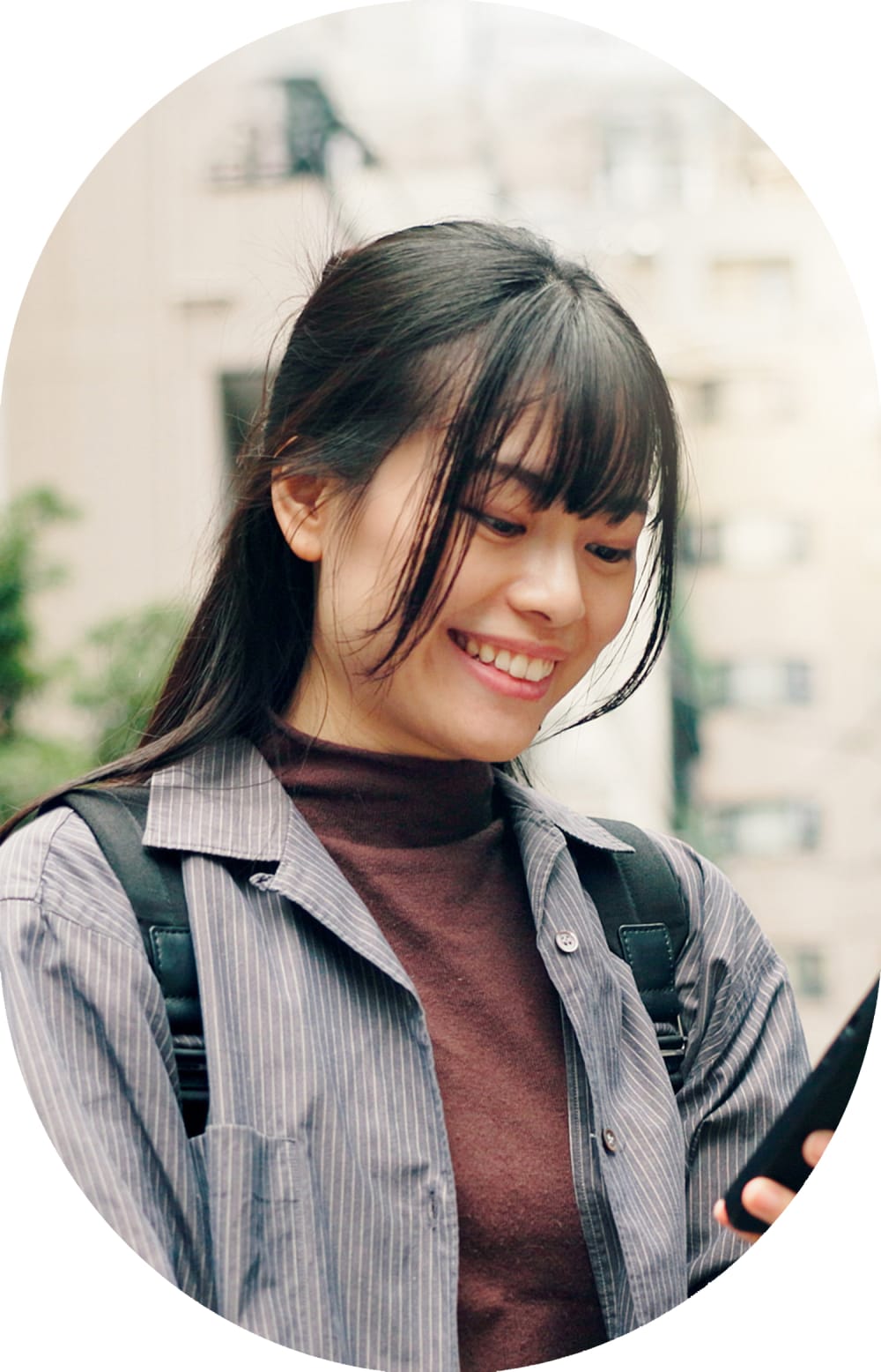 Woman stands outside smiling while wearing sunglasses.