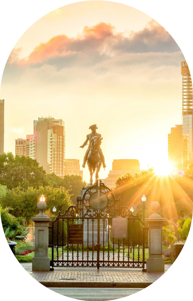 The equestrian statue of George Washington in Boston’s Public Garden with the sun shining in the background.