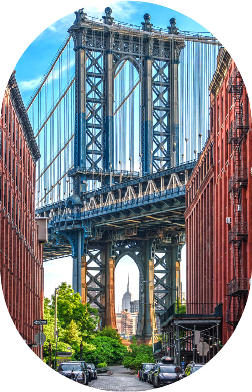 A woman stands outside smiling while holding up a clear aligner.