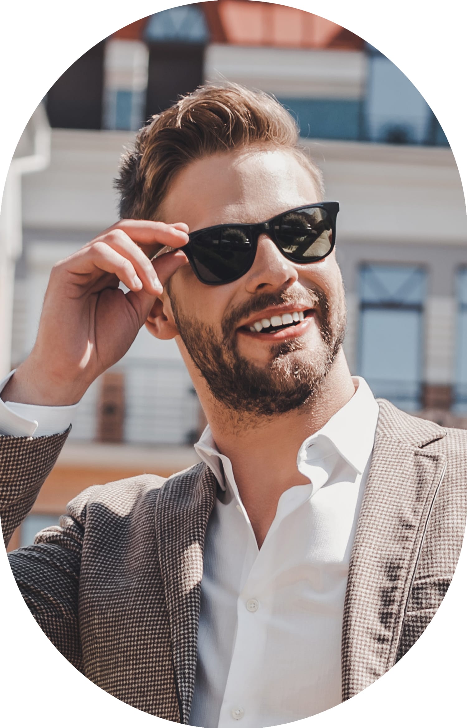 A man wearing sunglasses is smiling.