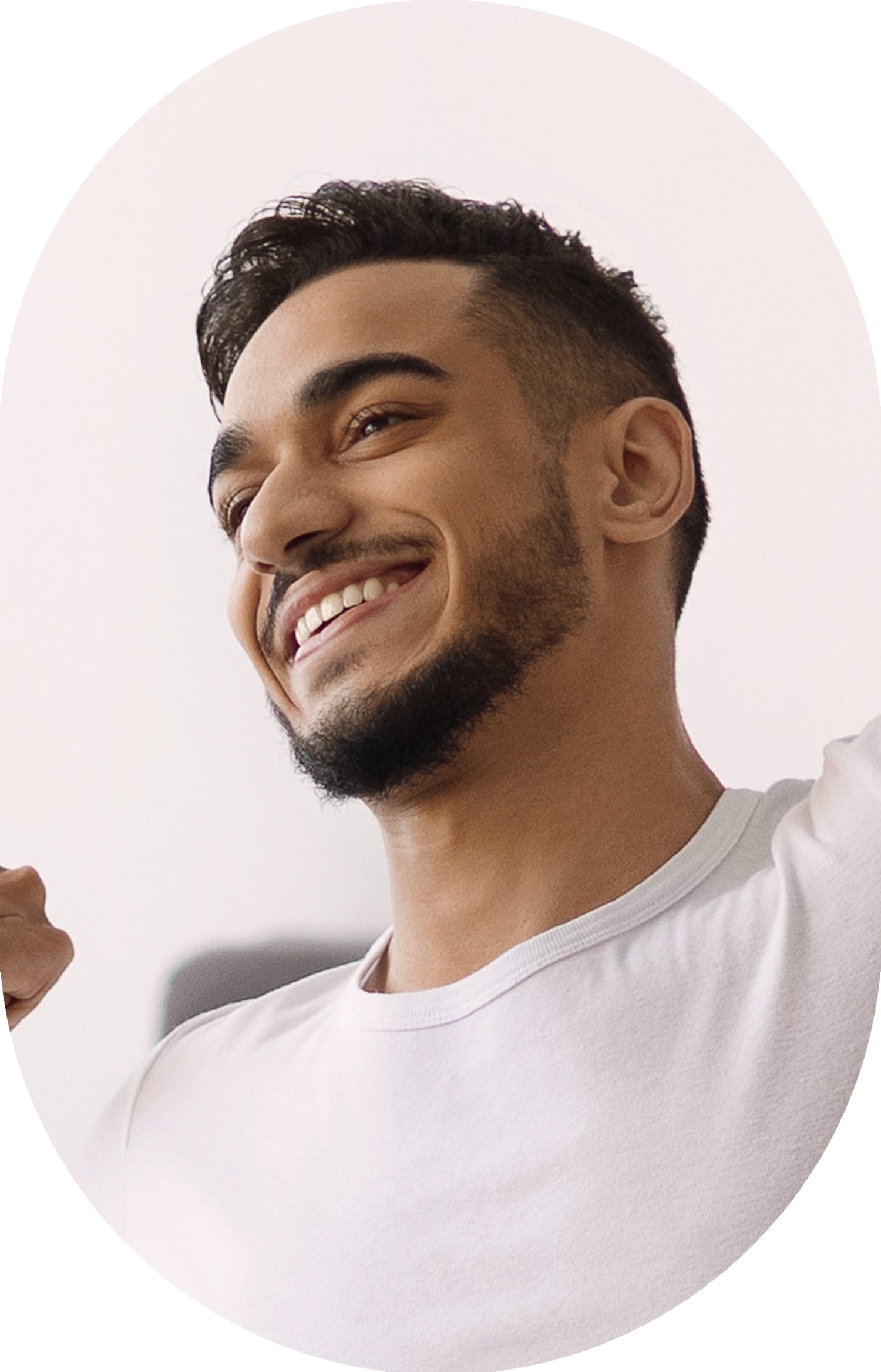 A man in a white t-shirt is smiling while stretching.