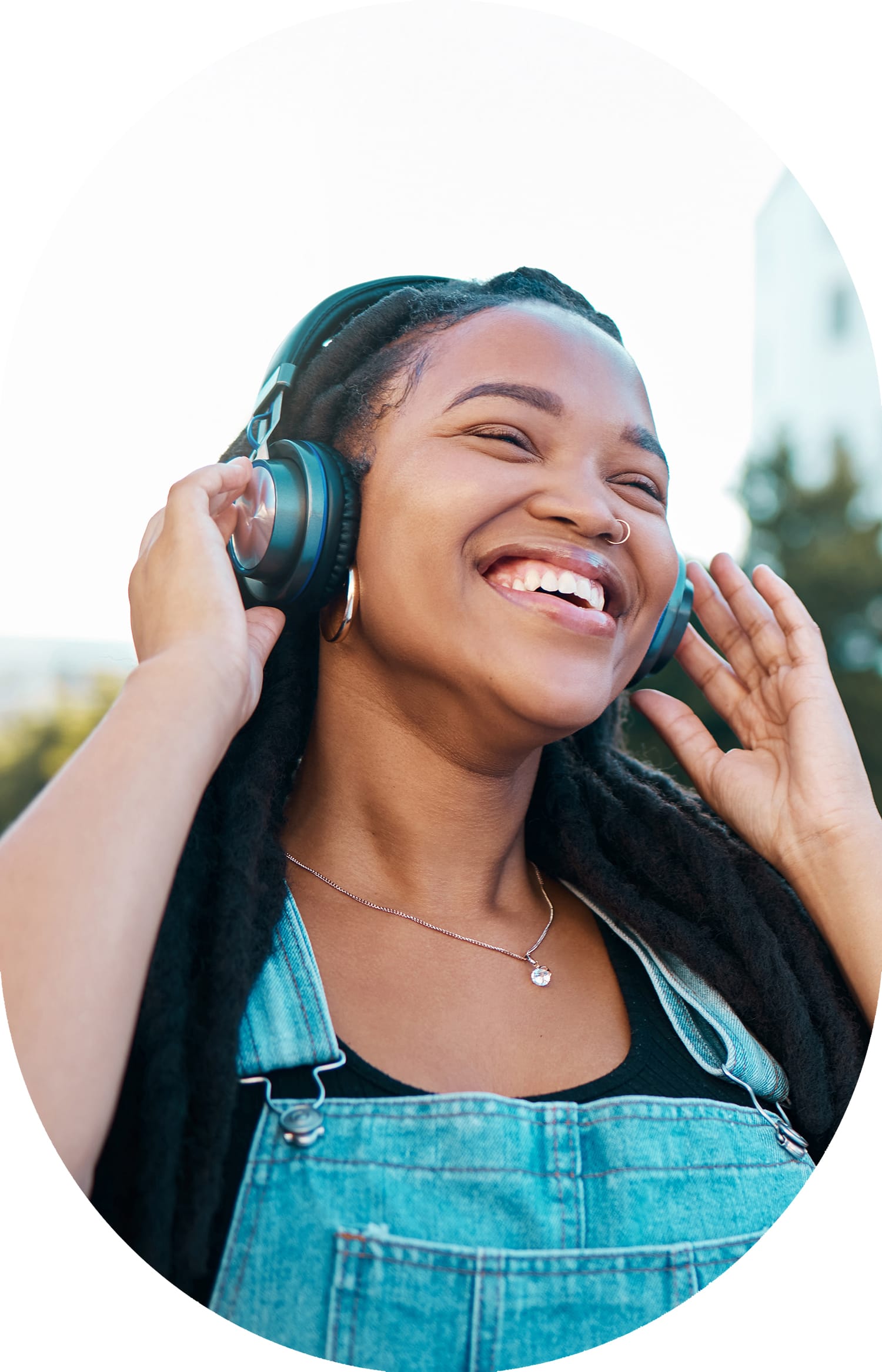 A woman wearing blue, smiling and wearing headphones.