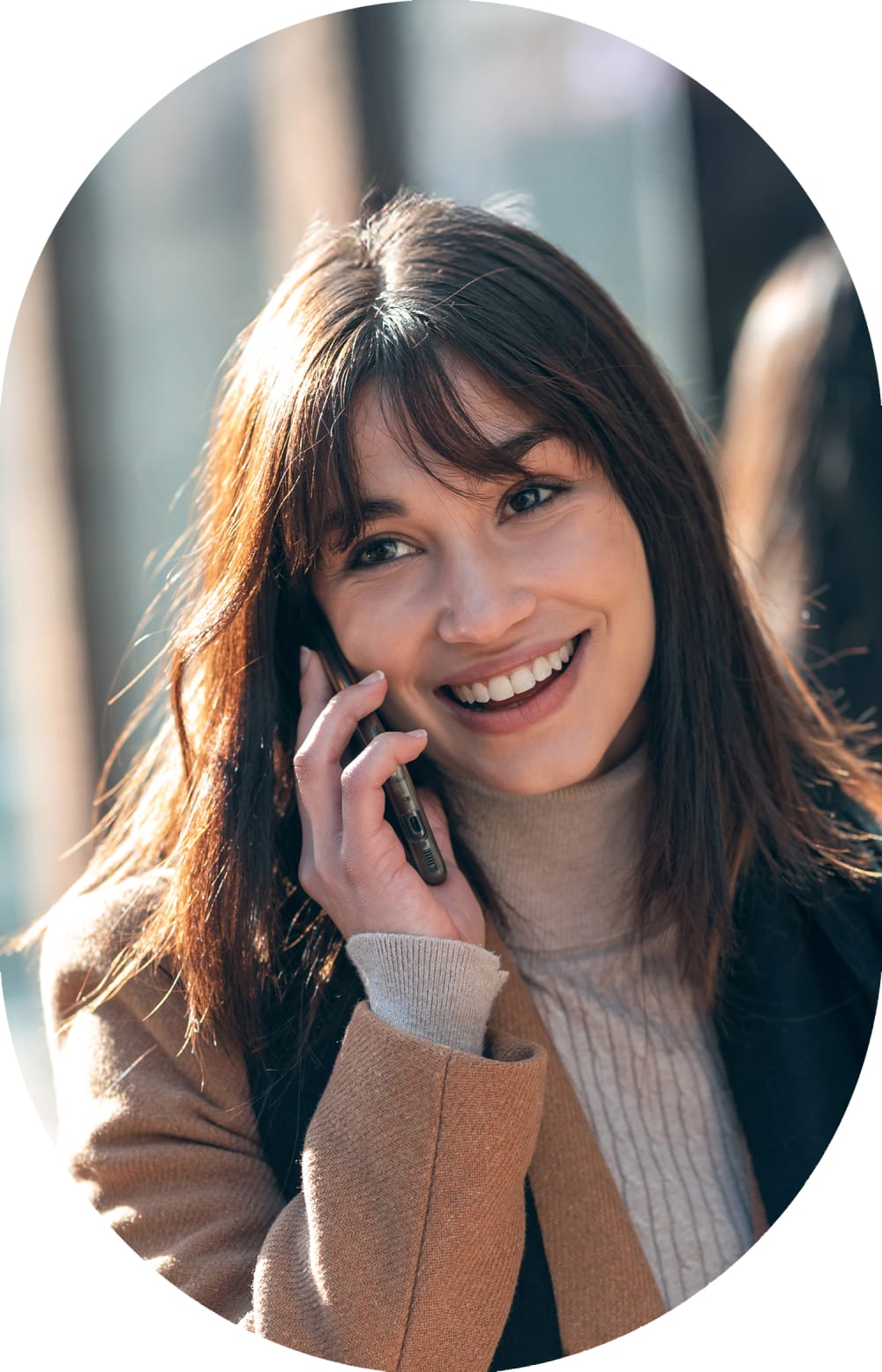 Woman stands outside smiling while wearing sunglasses.