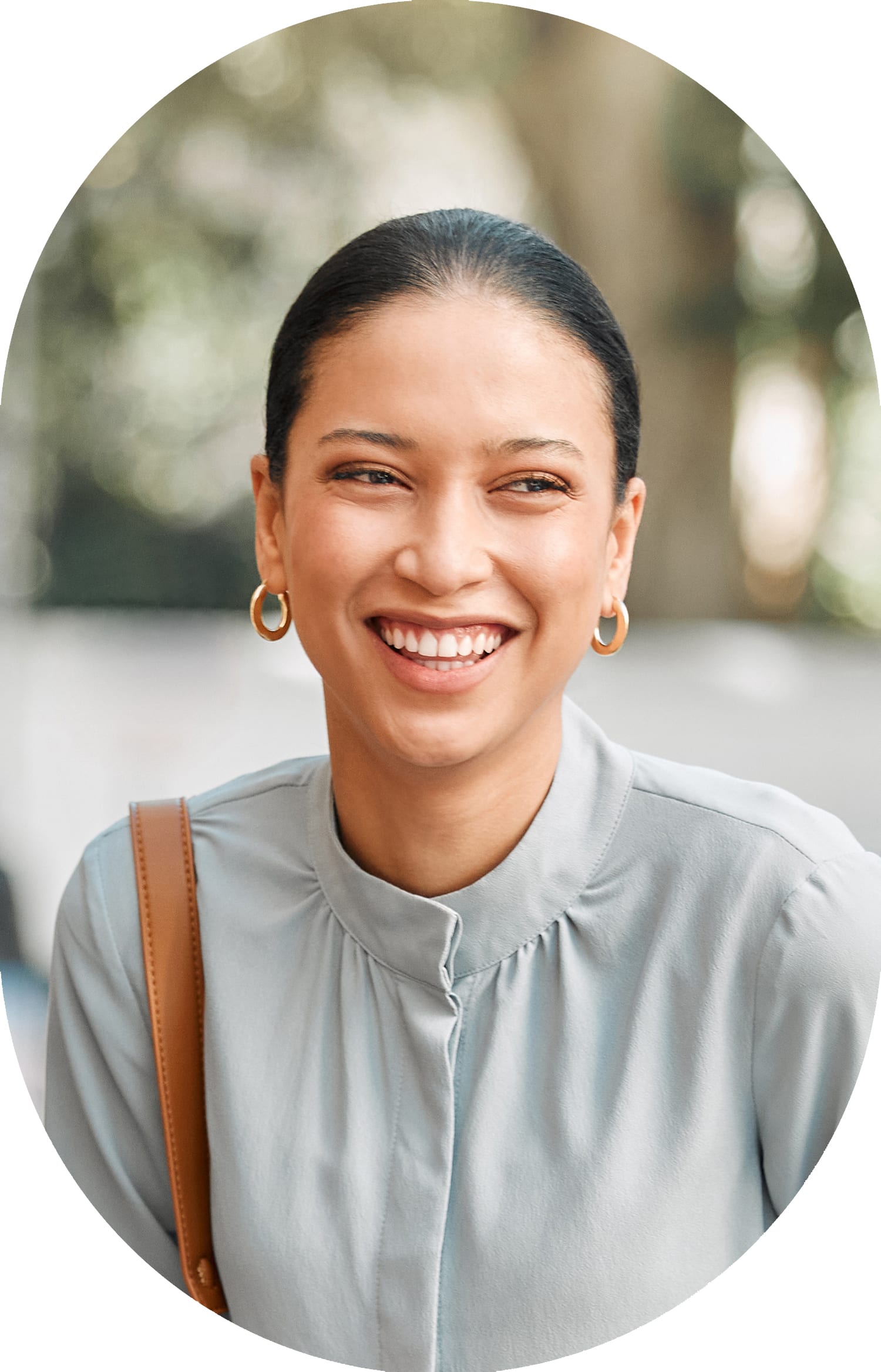Woman with her hair tied back, smiling while looking to the right.