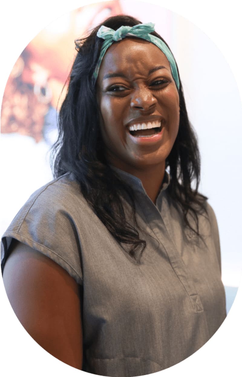 Smiling female team member wearing a Tend hairband, looking to her right.