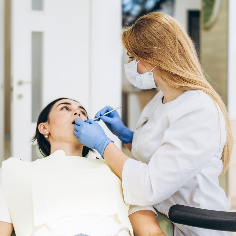 a patient is laying back in a treatment chair recieving care from a dental professional