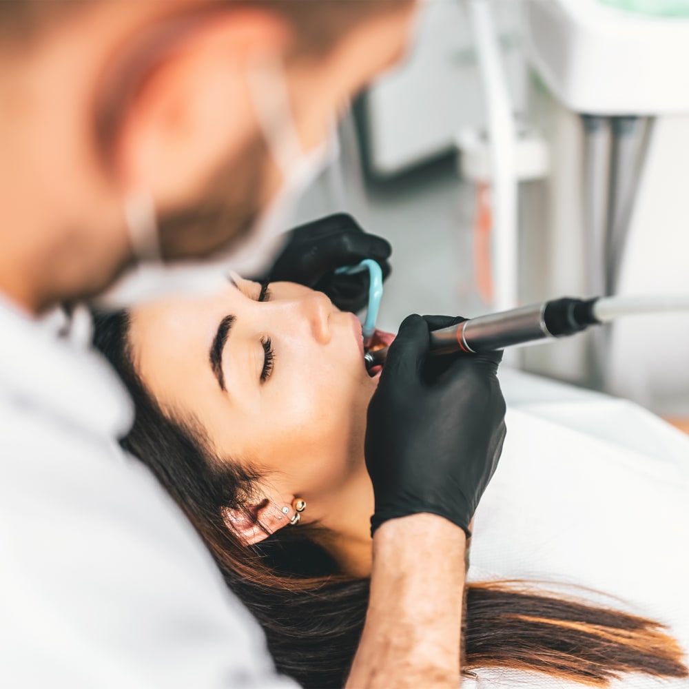 A female patient is relaxed while undergoing dental treatment.