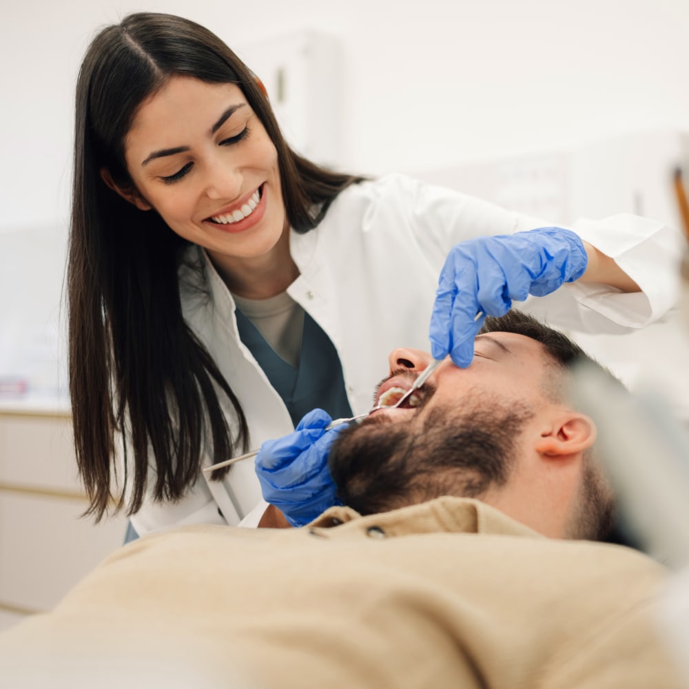 A female dental professional works on a patient's teeth.
