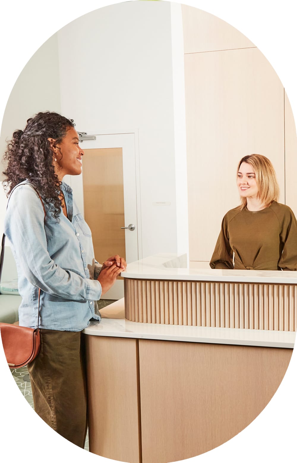 A woman speaks with a receptionist at Tend.